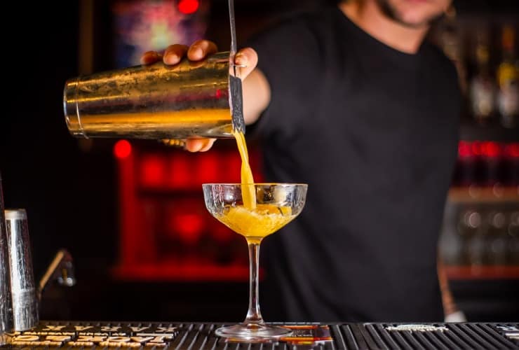 Person mixing a cocktail at a gay bar